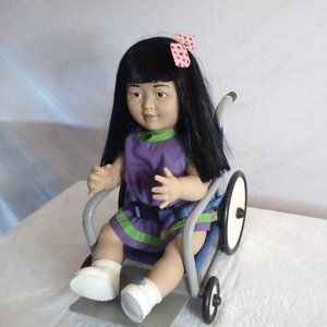 A cute doll in her wheel chair